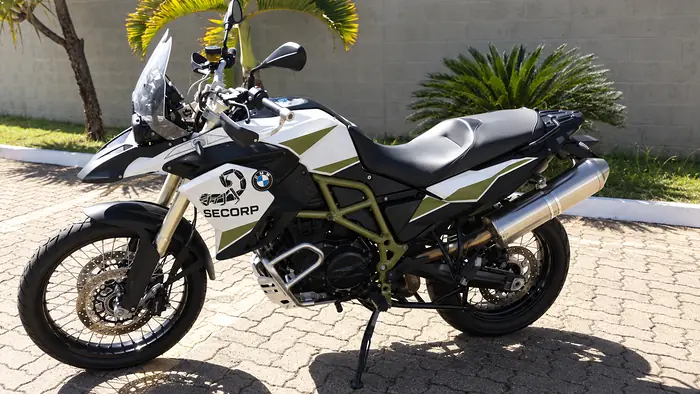 Motocicleta trail com grafismo SECORP branco, preto e verde-oliva